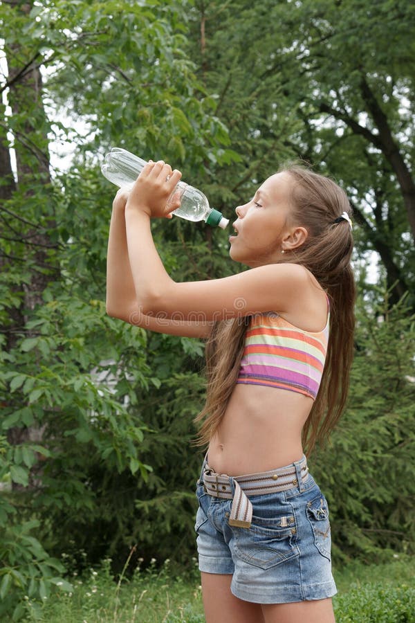 Preteen girl drinking watter stock image