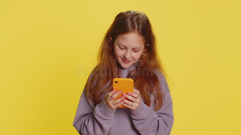 Preteen ребенок девочка ребенок с помощью мобильного смартфона вводя новый пост в Интернете смс сообщение просмотр видео видеоматериал