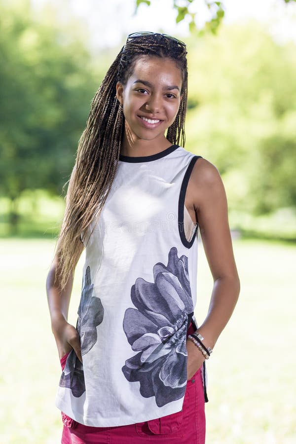 Pretty African American Teenage Girl Posing Outside in Park Area royalty free stock photo Pretty African American Teenage Girl Posing Outside in Park Area royalty free stock photo