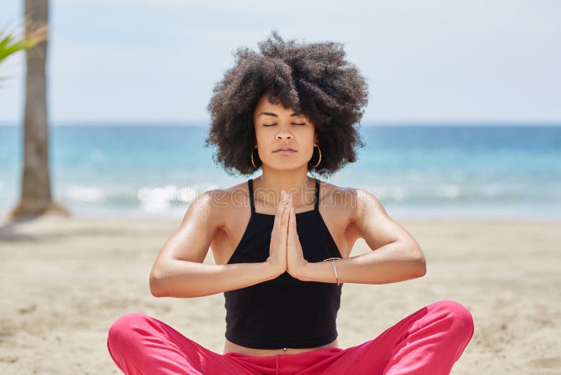 Pretty afro american woman meditating on beach royalty free stock photo Pretty afro american woman meditating on beach royalty free stock photo