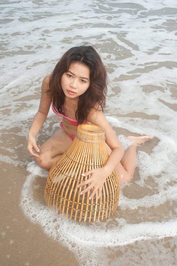 Pretty Asian woman posing on beach.