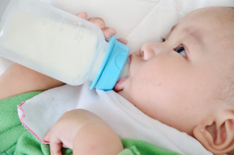 Pretty baby boy drinking milk from bottle