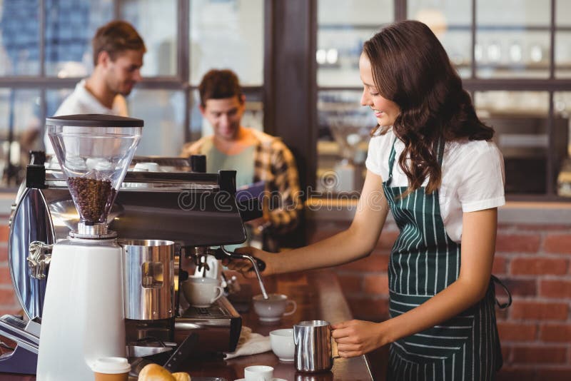 Pretty barista making a cup of coffee royalty free stock images
