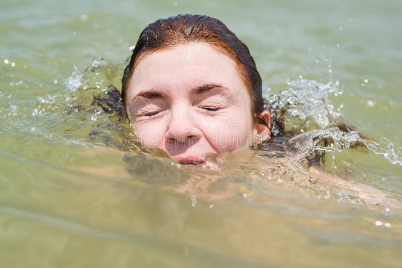 Pretty beautiful european woman drowning in the ocean