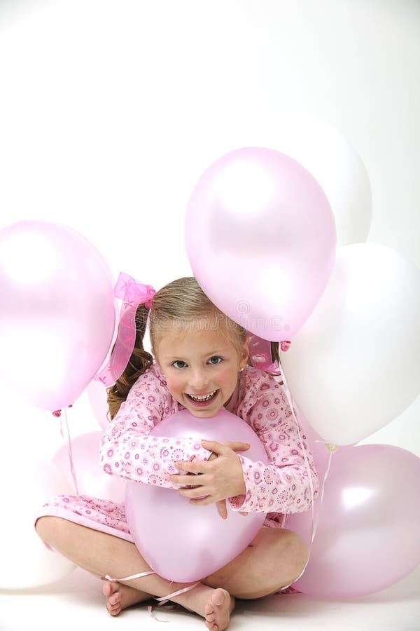 Pretty blond girl sitting between pink balloons