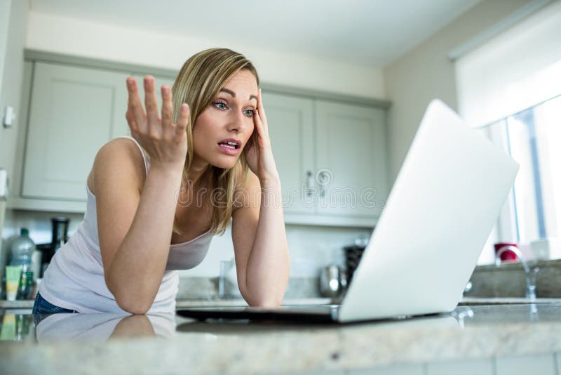 Pretty blonde woman looking at laptop at home. Woman doubtful looking stock images, royalty-free photos and pictures