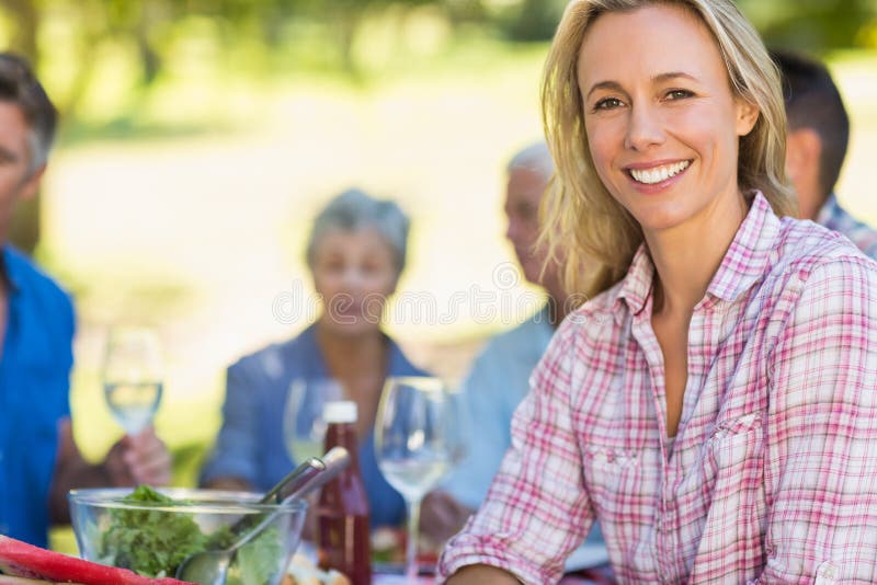 Pretty blonde women smiling at camera during a picnic on a sunny day. Pretty blonde women smiling at camera during a picnic on a sunny day