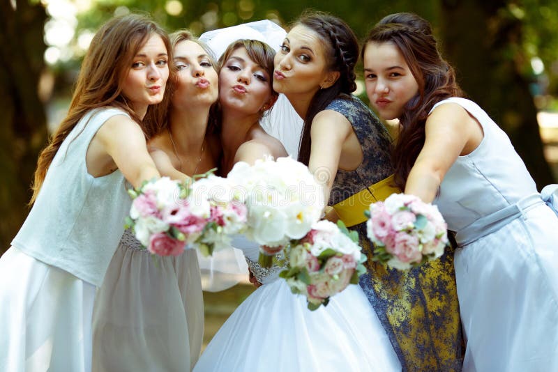 Pretty bridesmaids surround a bride holding wedding bouquets in