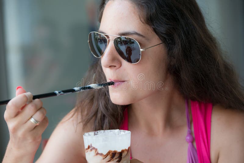 Pretty brunette drinking ice coffee