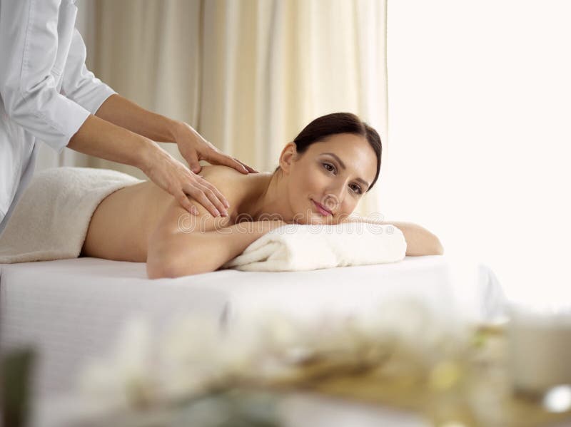 Pretty Brunette Woman Enjoying Treatment With Hot Stones In Spa Salon