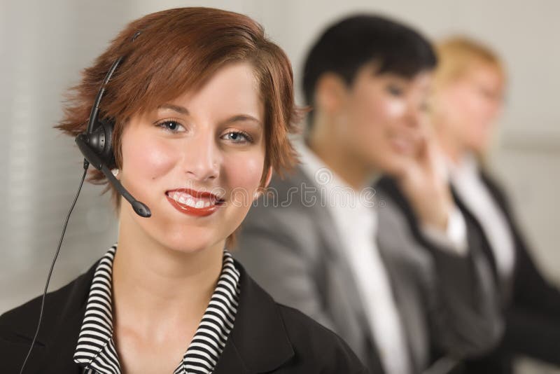 Pretty Businesswoman with Headset and Colleagues