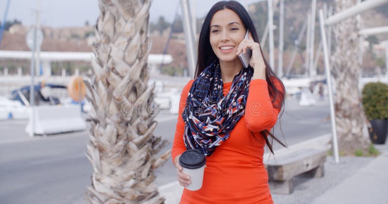 Pretty chic young woman chatting on a mobile