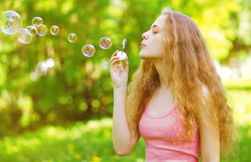 Beautiful Young Woman Blowing Soap Bubbles Stock Image