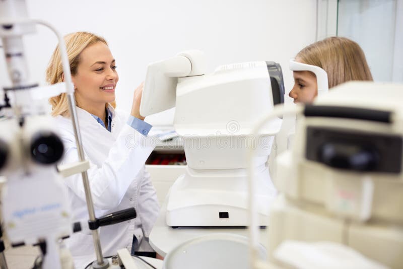 Pretty doctor at clinic checking girls vision royalty free stock photography Pretty doctor at clinic checking girls vision royalty free stock photography
