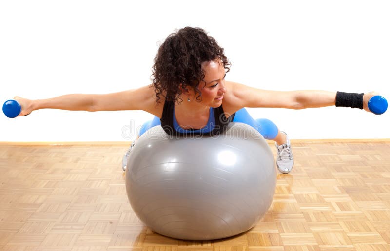 Pretty fitness girl with weights and ball