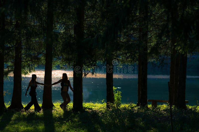 Pretty free hippie girls walking through the woods. Lake view - Vintage effect photo stock image Pretty free hippie girls walking through the woods. Lake view - Vintage effect photo stock image