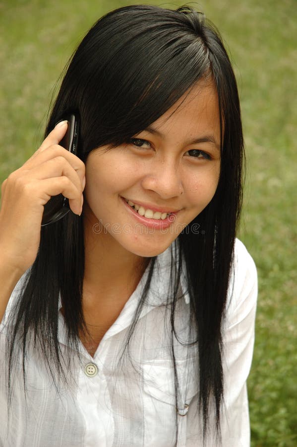 Pretty girl with black hair talking on phone.