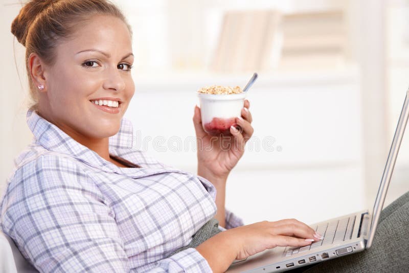 Pretty girl browsing Internet in bed smiling