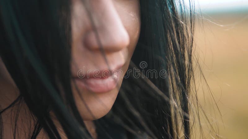 Pretty girl brunette large lips wind develops hair portrait shows the language flirts slow motion video. brunette woman