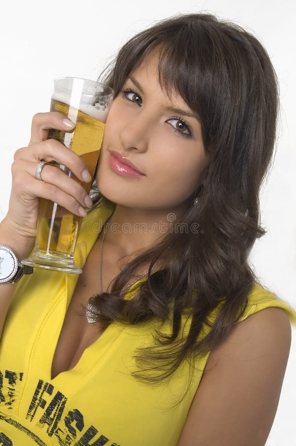 Pretty girl drinking beer from the glass stock photography