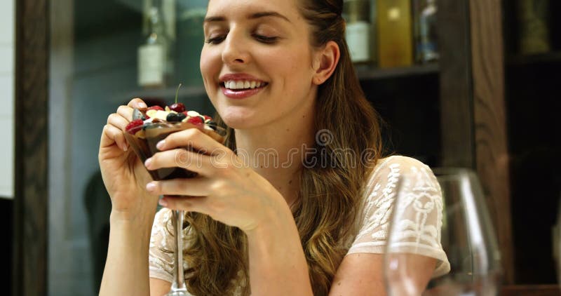 Pretty girl eating chocolate dessert