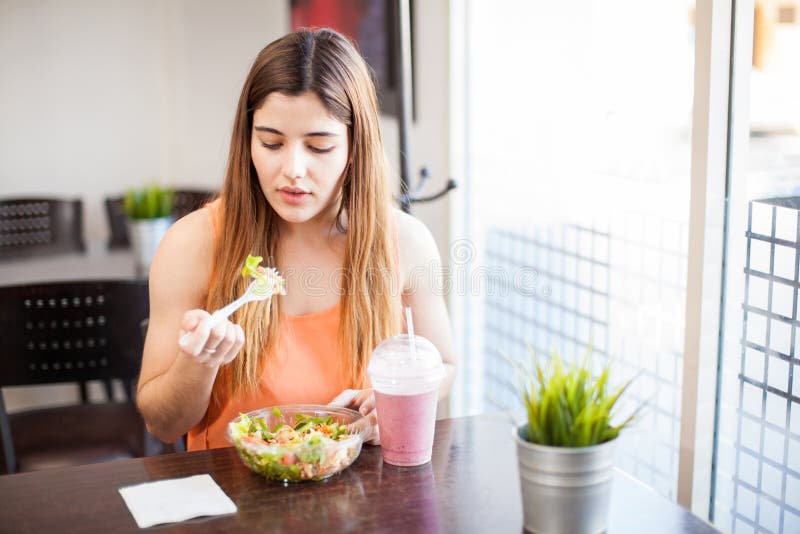 Pretty girl eating healthy food at a restaurant. 