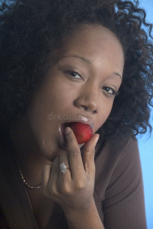 Pretty girl eating a strawberry