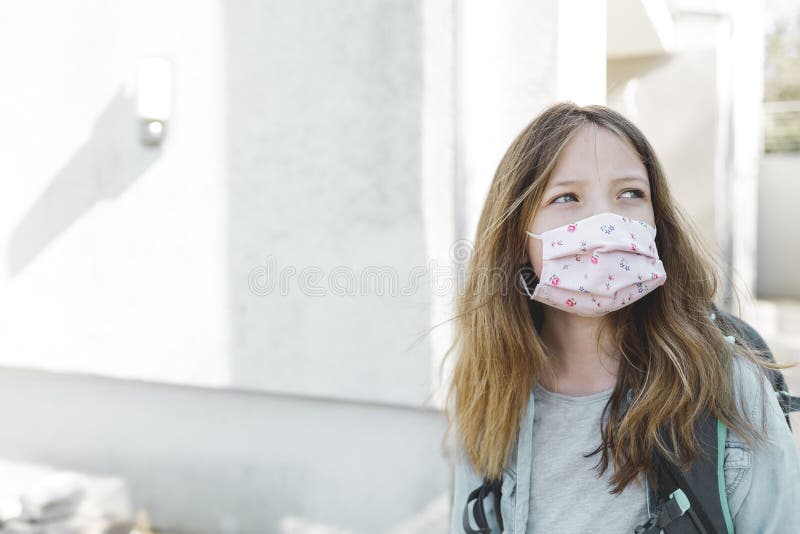 Pretty girl with nose mouth mask and school bag goes to school after corona quarantine royalty free stock images Pretty girl with nose mouth mask and school bag goes to school after corona quarantine royalty free stock images