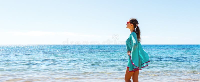 Pretty girl is posing in a blue dress at the sea background. Happy holiday concept royalty free stock photo Pretty girl is posing in a blue dress at the sea background. Happy holiday concept royalty free stock photo