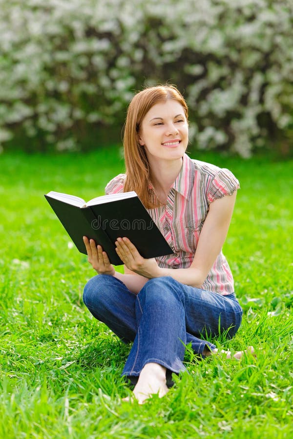 Pretty girl reading outdoors