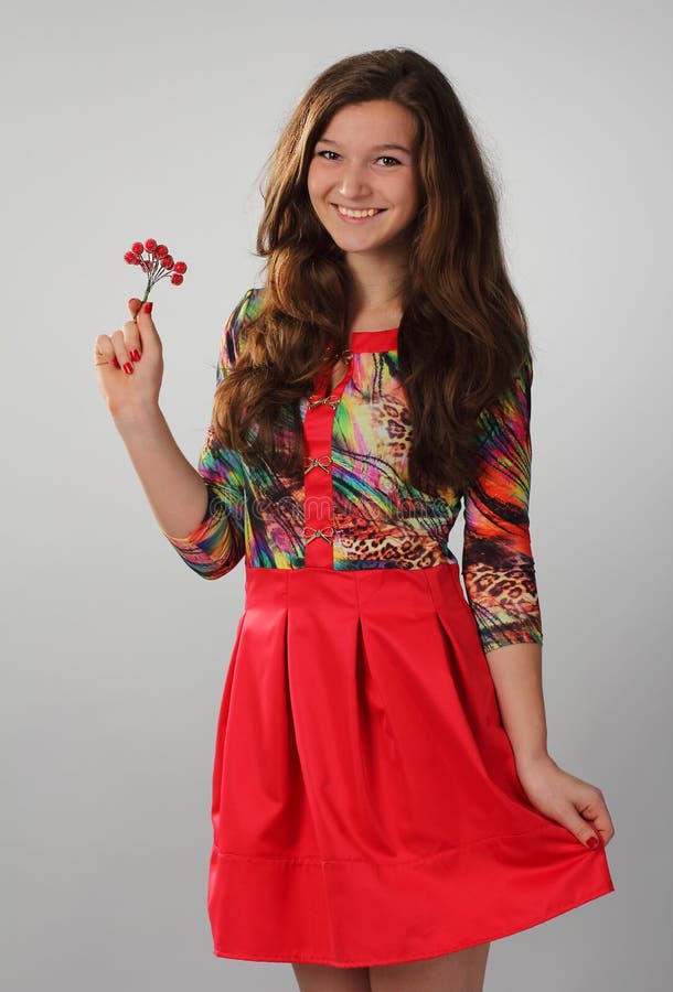 A pretty girl in a red dress with beautiful long brown hair. Photo in full growth. royalty free stock photo A pretty girl in a red dress with beautiful long brown hair. Photo in full growth. royalty free stock photo