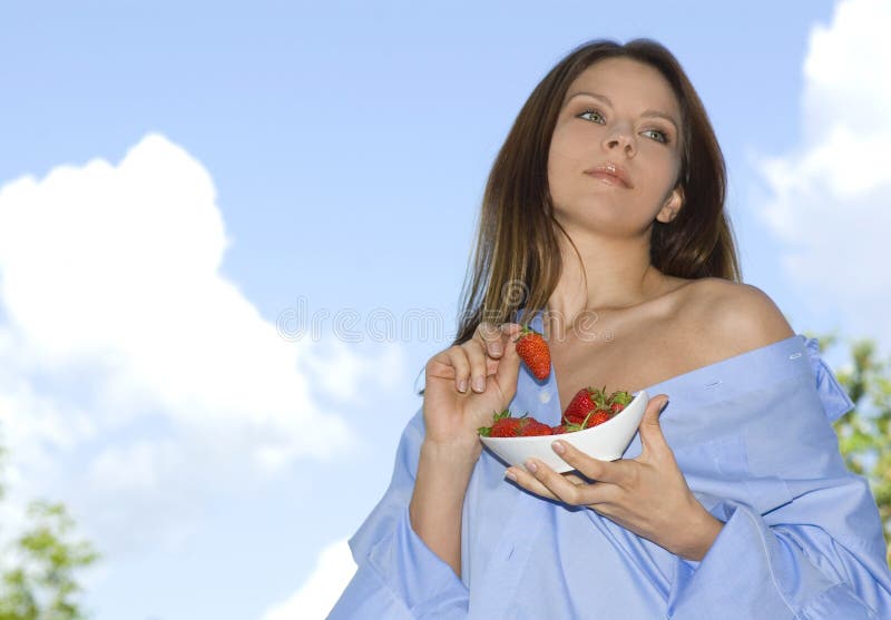 Pretty girl relaxing on balcony and eat red fresh