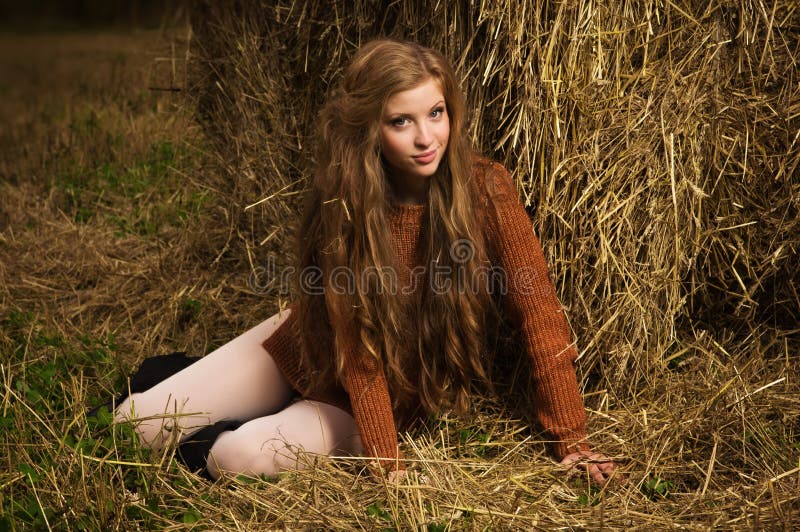 Pretty girl resting on straw bale