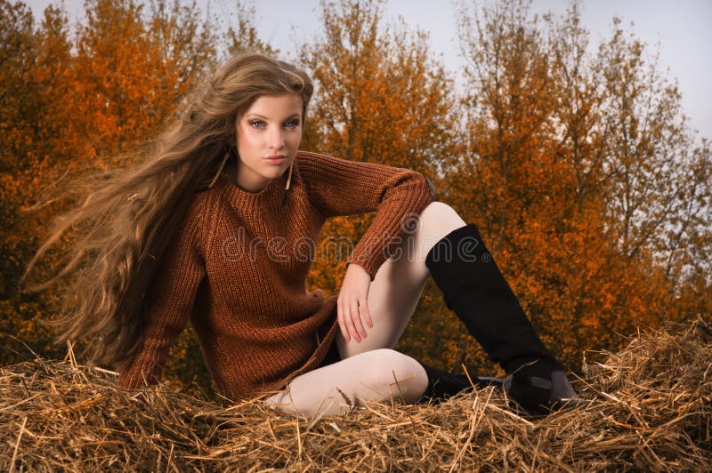 Pretty girl resting on straw bale