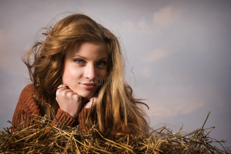 Pretty girl resting on straw bale