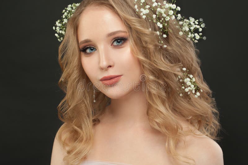 Pretty girl with white flowers on black, beautiful face closeup
