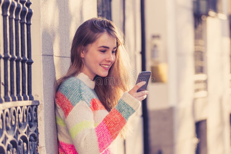 Attractive young woman on smart phone checking social media mobile apps outside city royalty free stock photos Attractive young woman on smart phone checking social media mobile apps outside city royalty free stock photos
