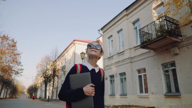 Pretty Hipster Teen Girl Walking Down Old City Street and Smiling. Schoolgirl with Red Bag Holding Laptop in Her Hand Stock Footage - Video of background, outdoors: 130307218