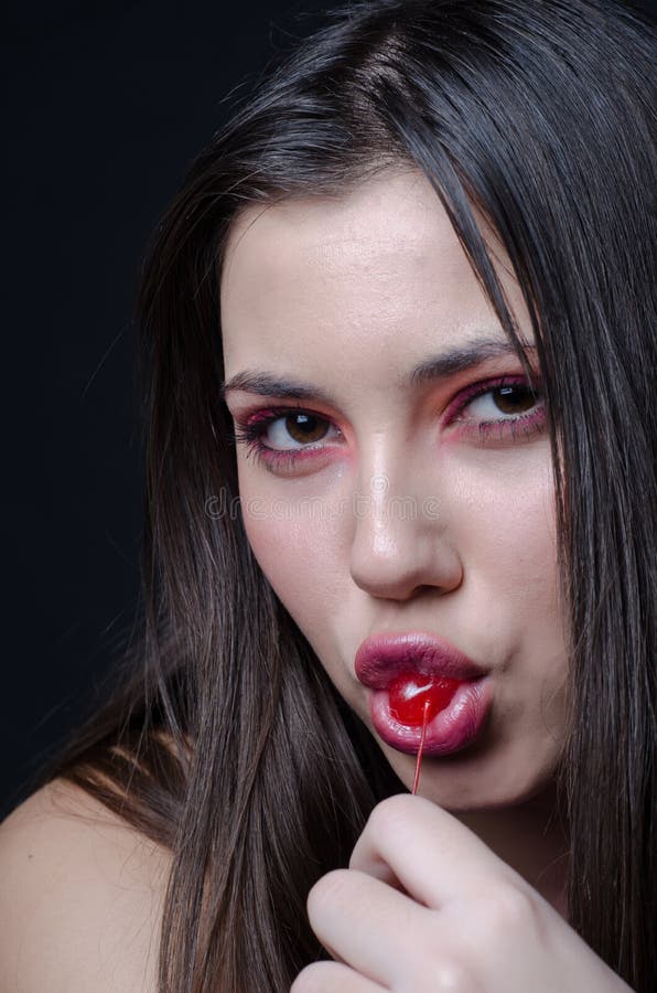 Pretty Lady With Fleshy Lips Sucking A Sweet Cherry Stock Photo