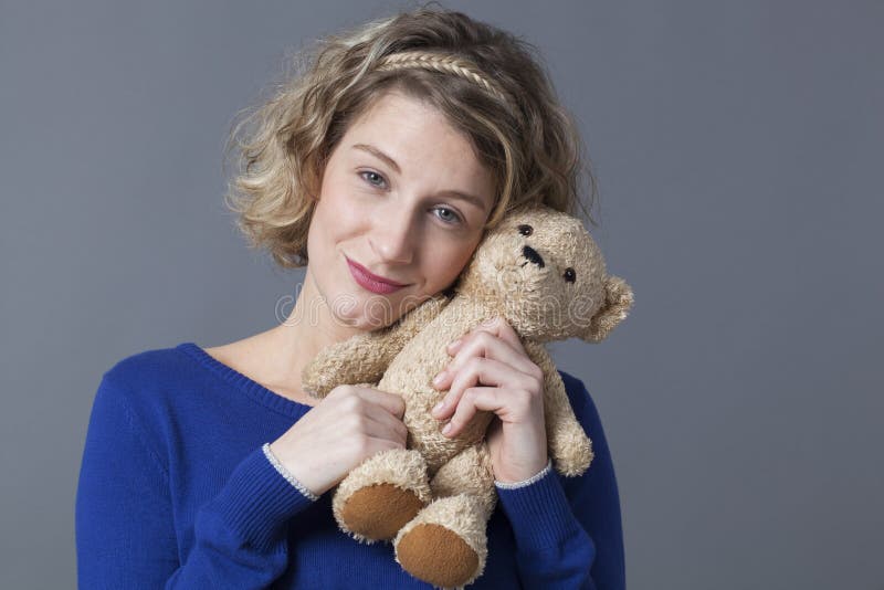 Pretty lady holding cuddly toy remembering childhood royalty free stock photography Pretty lady holding cuddly toy remembering childhood royalty free stock photography