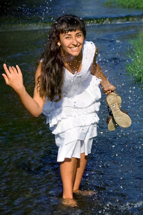 Pretty lady splashing in the stream