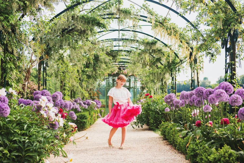 Pretty little girl playing in a beautiful garden