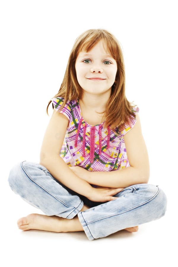 Pretty little girl sitting on the floor in jeans