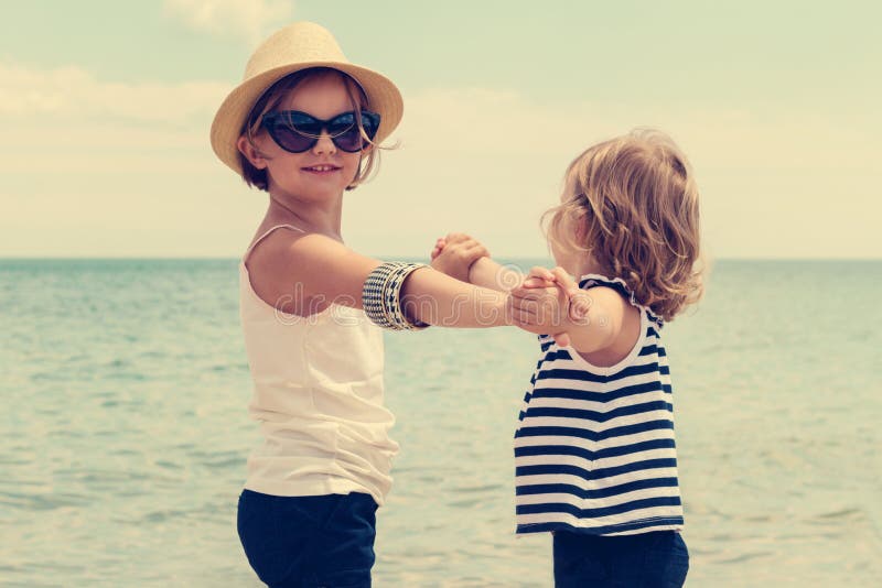 Pretty little girls (sisters) dancing on the beach. stock photo Pretty little girls (sisters) dancing on the beach. stock photo