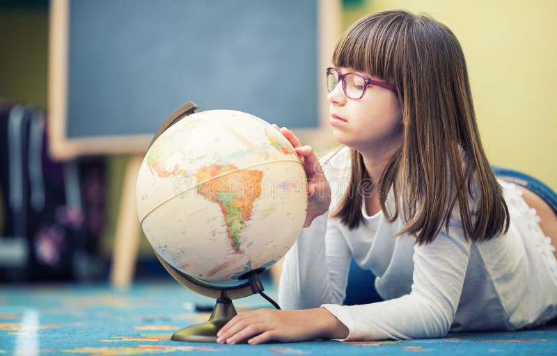 Pretty little student girl studying geography with globe in a child's room royalty free stock photo Pretty little student girl studying geography with globe in a child's room royalty free stock photo