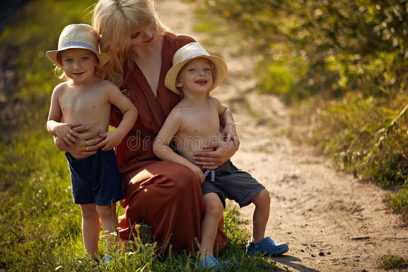 Pretty mother hugging her beloved sons stock photo Pretty mother hugging her beloved sons stock photo
