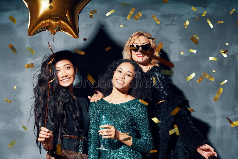 Pretty multiethnic young women have fun together celebrating with confetti on party royalty free stock image Pretty multiethnic young women have fun together celebrating with confetti on party royalty free stock image