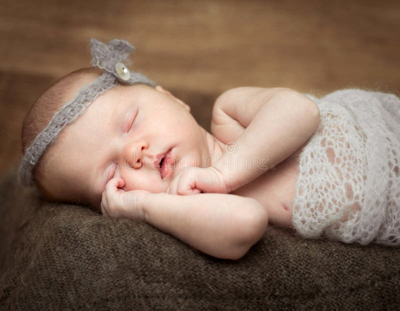 Pretty newborn girl sleeping on a cot