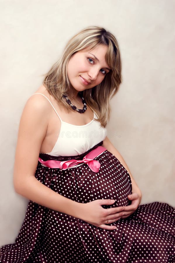 Pretty pregnant woman with pink ribbon