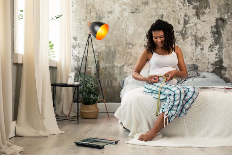 Pretty pregnant woman sitting on her bed. stock photography Pretty pregnant woman sitting on her bed. stock photography